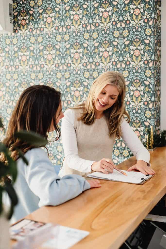 Woman consulting with a healthcare professional at Roots To Branches Clinic.